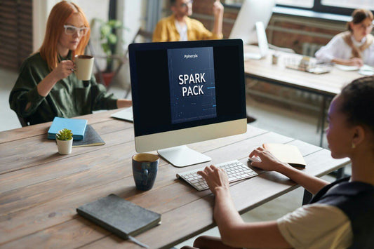 Person using a computer with 'Spark Pack' on the screen in an office setting.