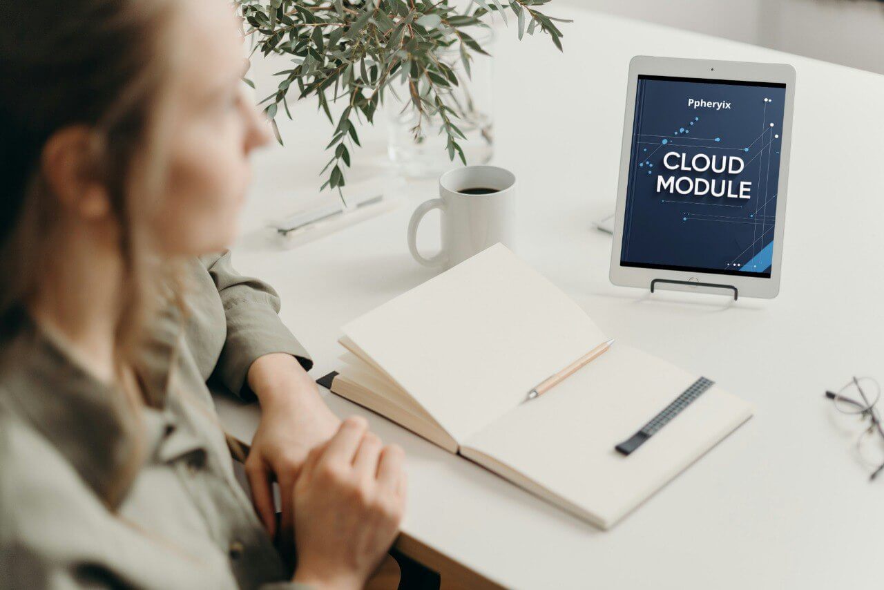 Person sitting at a desk with a tablet displaying 'Cloud Module' on a white surface.