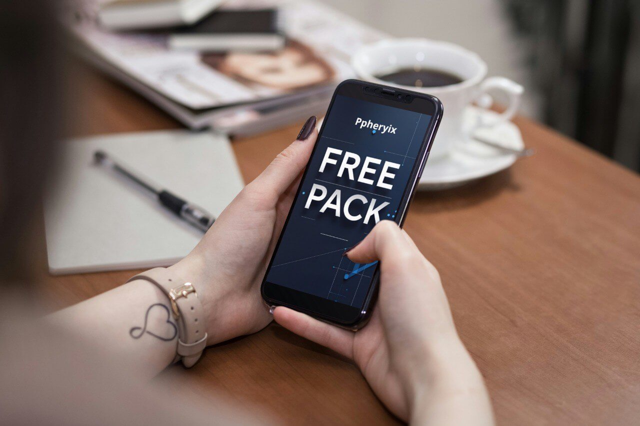 Person holding a smartphone with a "Free Pack" course PHP on a table with a cup of coffee and a magazine.