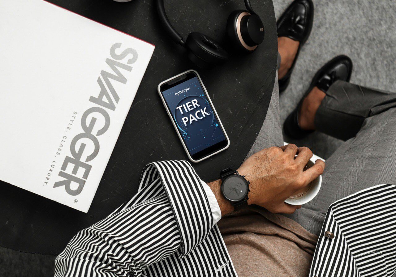 Person using a smartphone with a PHP course 'Tier Pack' app on a table next to a Swagger magazine